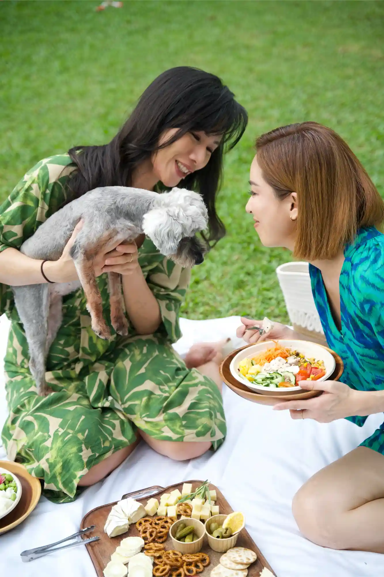 Julina Halim (Youhui) and Iriana Halim (Youyi), founders of Inside Out Academy Singapore, with their dog at a picnic