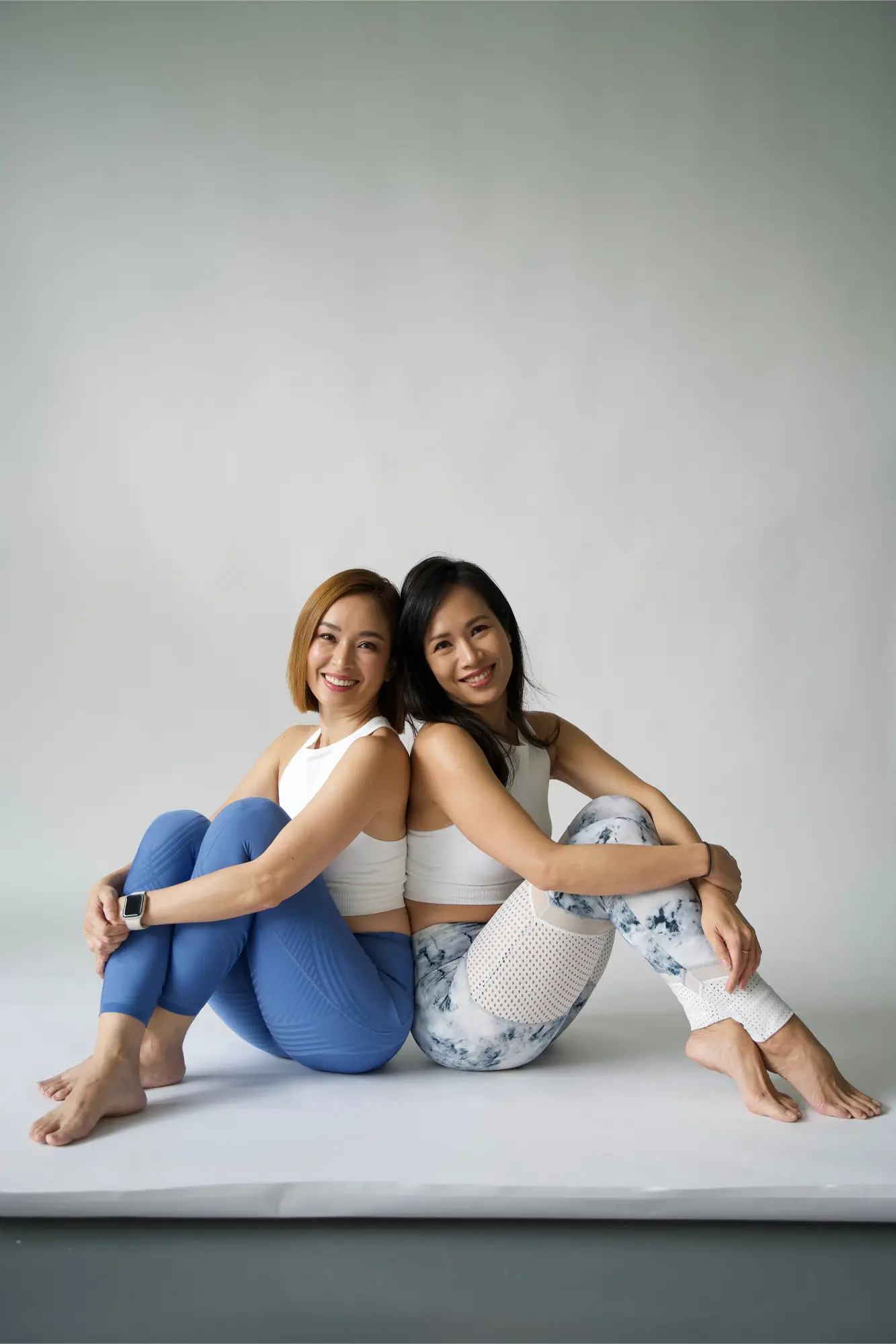 Julina Halim (Youhui) and Iriana Halim (Youyi), the founders of Inside Out Academy Singapore, sitting back to back